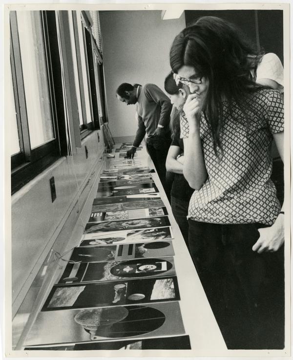 Professor Brown and students looking at printed-art during an exhibition