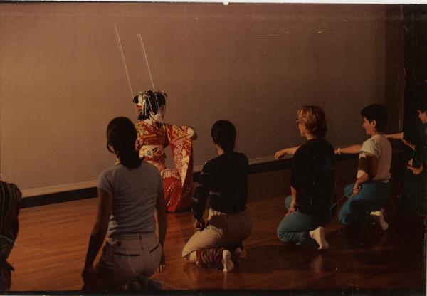 Japanese performer in front of kneeling students