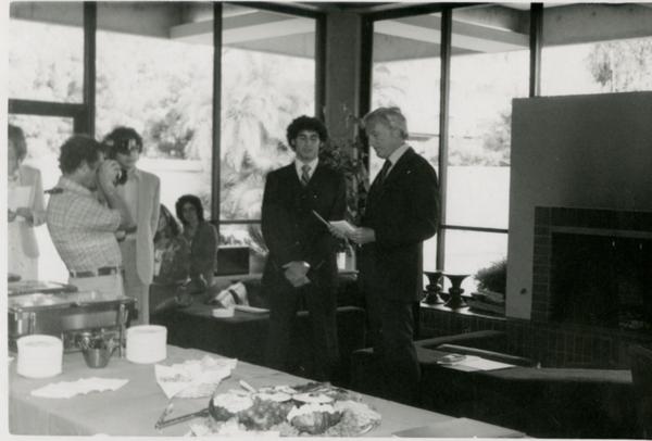 Speaker and unidentified man stand at front of the room during Goldwyn Reception, May 1981