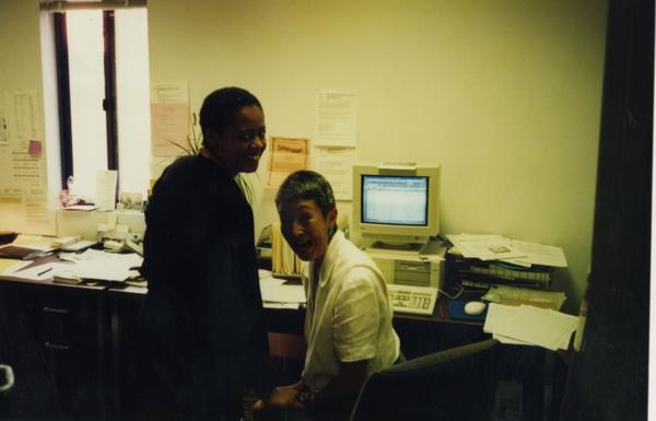 Two members of Dean's OFC Staff posing in front of computer