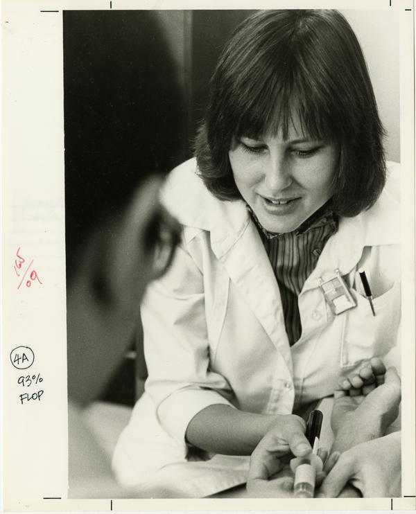 AIDS research: Researcher drawing blood from subject, 1983