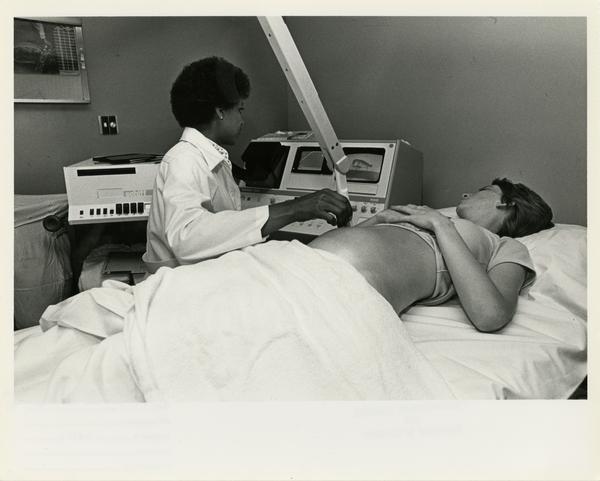 Doctor using Computerized Tomography Simulater on patient