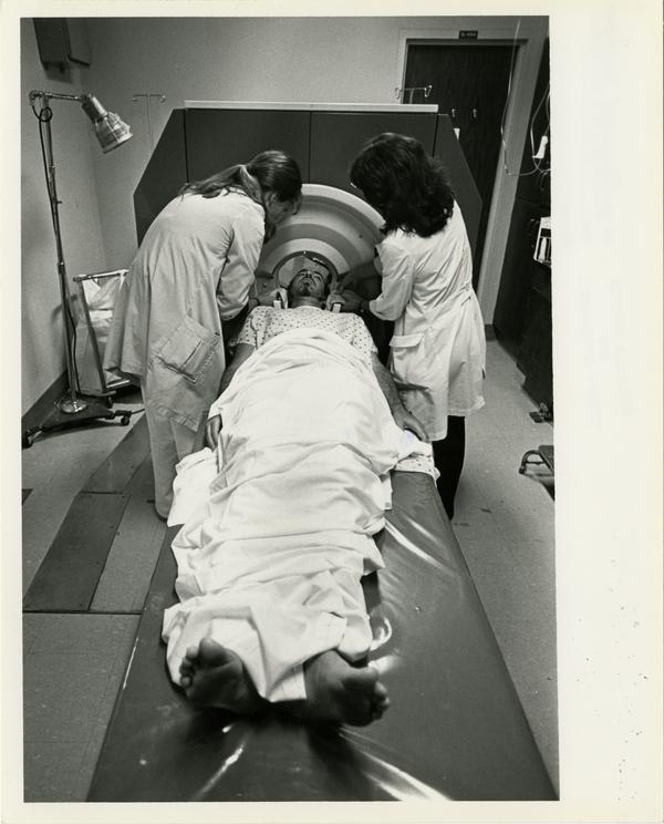 Two doctors position patient for the Computerized Tomography Simulater