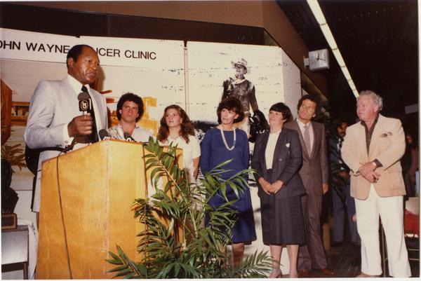 Speaker at podium at opening event for John Wayne Cancer Clinic, 1981