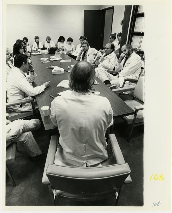 Doctors seated around conference table at Jonsson Comprehensive Cancer Clinic event, 1981