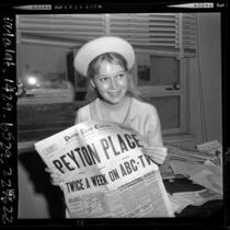17 year old Mia Farrow holding Peyton Place newspaper as she waits for contract approval in Santa Monica courthouse, 1964