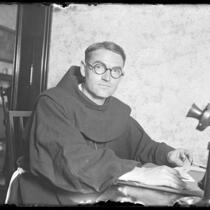 Father Superior Augustine seated at his desk at Santa Barbara Mission, Calif., 1925