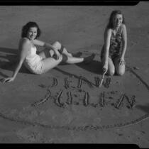 Young women writing in sand, Santa Monica, 1938