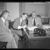 Franchot Tone signs waiver as District Attorney S. Ernest Roll (right) and personal attorney Henry Herzbrun (left) look on, 1951.