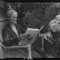 Mary Van Ness Leavitt reading a magazine in her garden, Santa Monica, 1928
