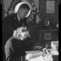 Actress Boots Mallory and an official in a Santa Monica harbor Department office, Santa Monica, 1937