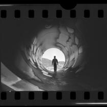 Workman walking through pipe at Castaic Hydroelectric Power Plant, Calif., 1976