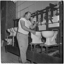 Employee making toilet bowls at the Universal-Rundle ceramic factory, Redlands, 1940s