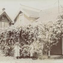 Woman stands in front of flower tree outside Los Angeles residence