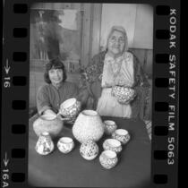 Writer and potter Susan Peterson with American Indian potter Lucy Lewis displaying Lewis' work in Los Angeles, Calif., 1984