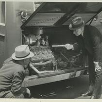 Two men inspecting railway car engine