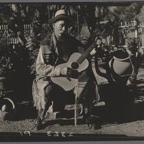 Eugene R. Plummer with guitar and Indian artifacts, Hollywood, 1927