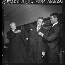 William R. Ely, Judge W. R. Ely, helping Walter Ely put on his judicial robes in Los Angeles, Calif., 1964