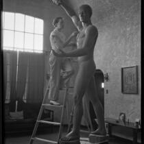 Nina Saemundsson working on her statue of Prometheus Bringing Fire to Earth in her studio, Los Angeles, 1934