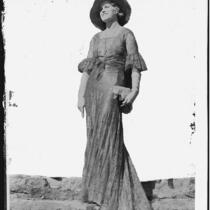 Peggy Hamilton modeling a lace evening gown and wide-brim hat, circa 1929-1933