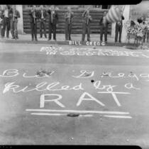 Chalk writing in front of a street shrine for longshoreman Norman "Big Bill" Gregg, San Pedro, 1937