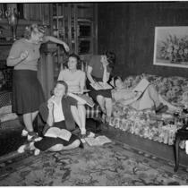 Group of young women read books and write together at their USC sorority house, Los Angeles, 1940