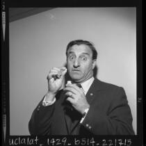 1/2 length portrait of comedian Danny Thomas with pills he takes for his voice, 1963