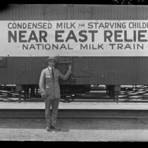Adelbert Bartlett in front of railroad car with sign for Near East Relief, 1922-1929