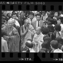 Tenzin Gyatso, Dalai Lama XIV surrounded by people during visit to Vietnamese Temple in Los Angeles, Calif., 1984