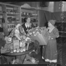 Aimee Semple McPherson and Mrs. M. B. Godbey in a pantry preparing food baskets, Los Angeles, 1935