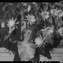 Carolyn Briggs posing with night blooming cereus flowers, Santa Monica, 1934