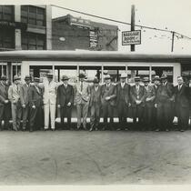 Men standing in front of parked bus