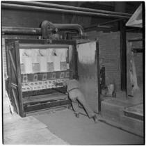 Employee loads newly made toilets into a kiln at the Universal-Rundle ceramic factory, Redlands, 1940s