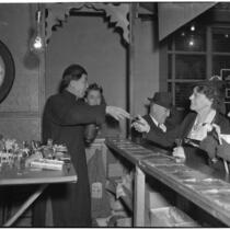 Charlie Chan, fortune teller, speaks to customers in Chinatown, Los Angeles, 1930s