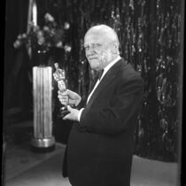 Founder and president of Universal Pictures, Carl Laemmle holding an Oscar trophy, 1930