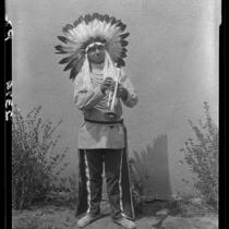 Young man in Indian regalia with trumpet, 1928