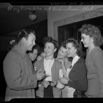 Actor Roy Rogers signing autographs for group of girls at United States Army induction station, 1945