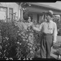 Eugene R. Plummer and woman in flower garden at his home, Hollywood, 1927