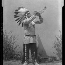 Young man in Indian regalia playing trumpet, 1928