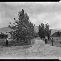 Two men, house and barn in valley, California