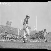 Los Angeles Rams' Jon Arnett running through line of Ramettes, 1958