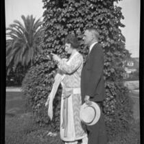 Man and woman standing near ivy-covered tree, [1920-1923?], rephotographed 1924