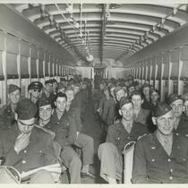 A group of service men sitting inside a bus