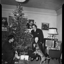 Tenor Julian Oliver and family near Christmas tree, 1951