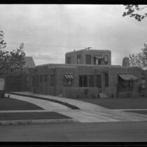 Exterior view of an unidentified house with striped awnings, California
