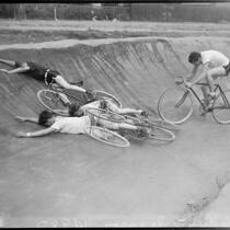 Cyclists lie on the track during practice for  a six-day bicycle race at Pan-Pacific Auditorium, Los Angeles, 1937