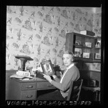 Writer Helen Addison Howard seated at desk with her book "Saga of Chief Joseph," 1966