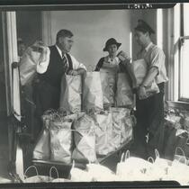 Police Lieutenant George Fisher, city mother Elizabeth Fiske, and patrolman J.W. Buckley with bags of Baghdad coffee, Los Angeles