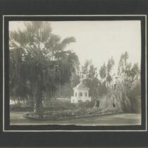 Woman walking through park with gazebo in background, Los Angeles