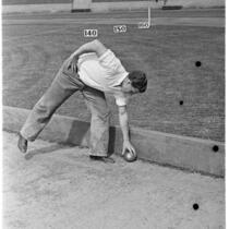 Sports official retrieving the shot at a track meet between UCLA and USC, Los Angeles, 1937